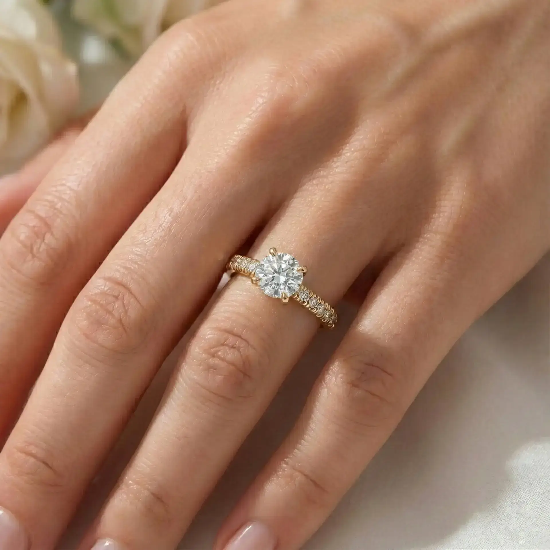 טבעת אירוסין עדינה על היד עם יהלום מרכזי ושיבוץ יהלומים בצדדים לואיזה