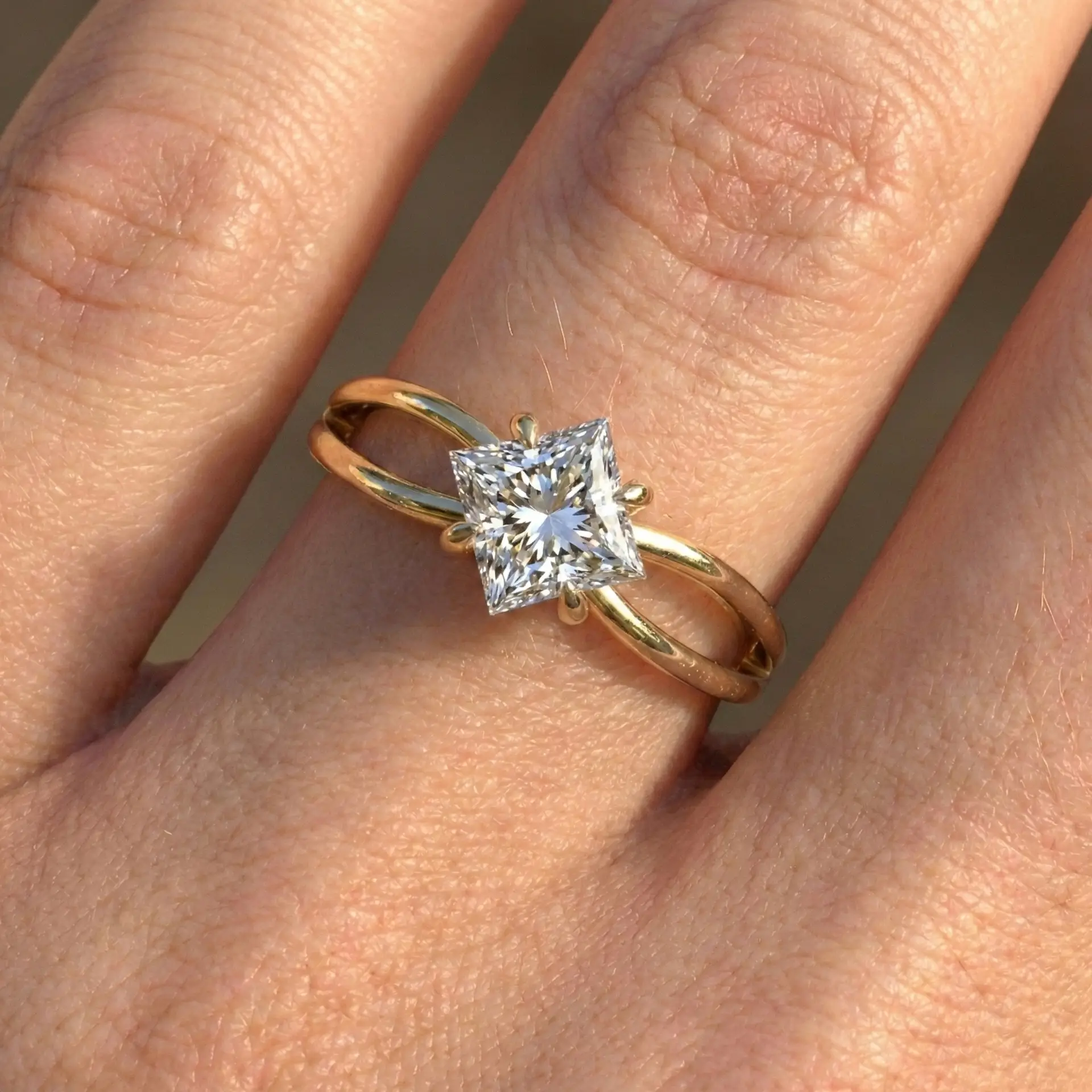 טבעת אירוסין סוליטר יהלום פרינסס צהוב על יד טבעת אירוסין זהב 14k עם יהלום פרינסס מרובע וחישוק כפול בחזית.